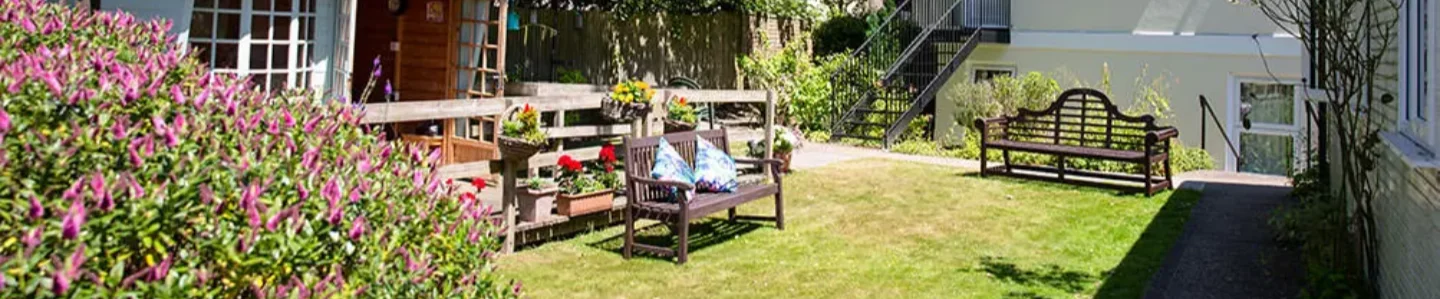 Beulah Lodge Rest Home A view of Beulah Lodge garden with bench and summer house